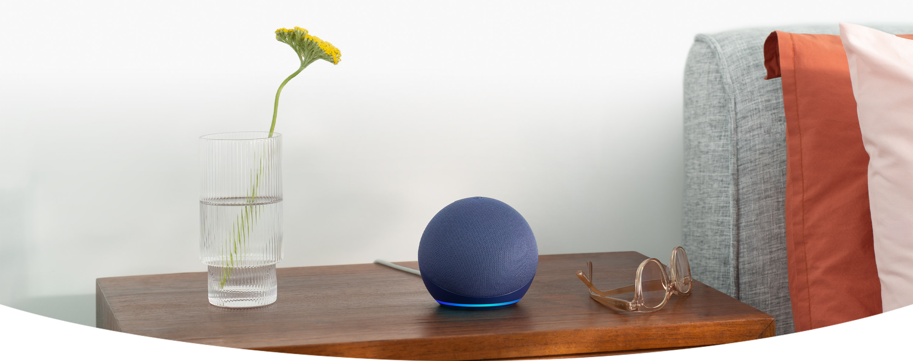 Amazon Echo Dot azul sobre uma mesa de cabeceira